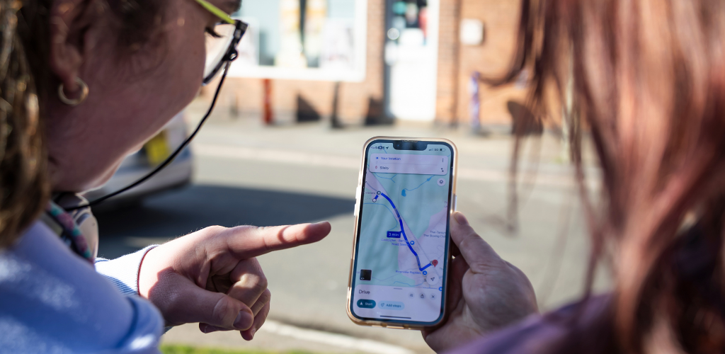 two students looking at a Google Maps route on a phone